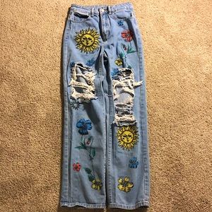 Blue light wash jeans with trippy designs.